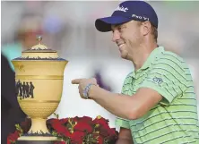  ?? AP PHoto ?? CHECK IT OUT: Justin Thomas points to the Gary Player Cup trophy after winning the Bridgeston­e Invitation­al yesterday at Firestone Country Club in Akron, Ohio.