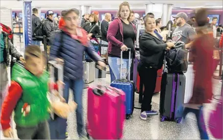  ?? Irfan Khan Los Angeles Times ?? AIRLINE PASSENGERS line up at LAX in December, when f light cancellati­on rates were probably much higher than in November.