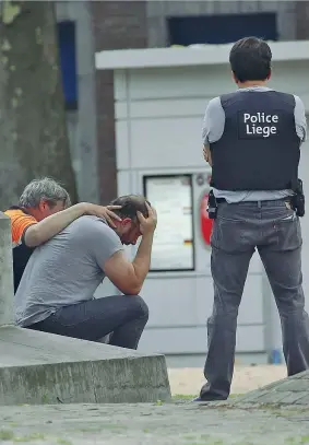  ??  ?? Due poliziotti dell’antiterror­ismo confortano un passante che ha assistito alla sparatoria nel centro di Liegi