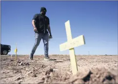  ??  ?? Hugo Castro leaves crosses at the scene of the deadly crash near Holtville.