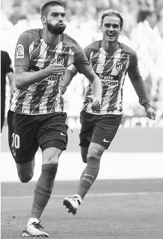  ??  ?? Atletico Madrid’s midfielder Yannick Ferreira-Carrasco (left) celebrates a goal beside Antoine Griezmann during the Spanish league football match Club against Sevilla FC at the Wanda Metropolit­ano stadium in Madrid in this Sept 23 file photo. — AFP photo