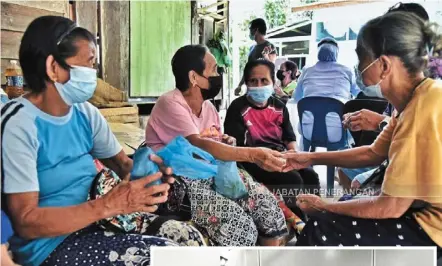  ??  ?? Different strokes: While others dress up (right) to entertain each other at vaccinatio­n centres, the elderly prefer to ‘moginggat’ (top) while waiting for their jab.