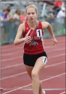  ?? JEFF DOELP — SPECIAL TO THE READING EAGLE ?? Above right, Wilson’s Katie Dallas runs the anchor leg of Wilson’s winning 3200relay. Above left, Fleetwood’s Chanel Hercules, center, is congratula­ted by teammates after winning the girls’ 300-meter hurdles.