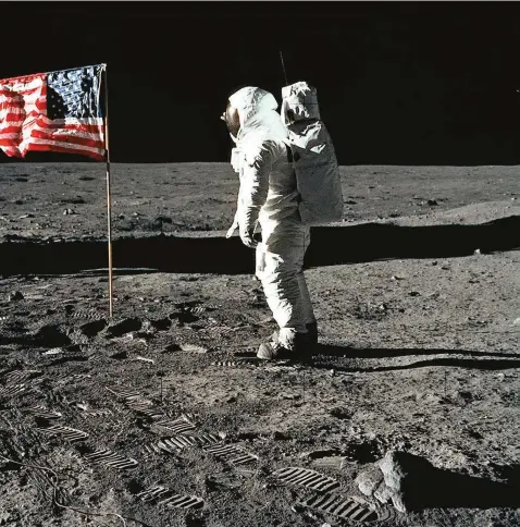  ?? FOTO NASA ?? El módulo lunar está a la izquierda y se ven las huellas de los astronauta­s. Salta a la vista la bandera de Estados Unidos, como triunfador de una carrera espacial de décadas.