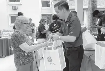  ?? FPL ?? FPL External Affairs Manager Chris Ferreira hands a hurricane meal kit to a Miami-Dade senior.