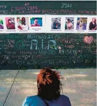  ?? MATT ROURKE/AP ?? A person on Thursday visits a makeshift memorial near the scene of the Saturday shooting at a supermarke­t, in Buffalo, New York, that left 10 people dead.