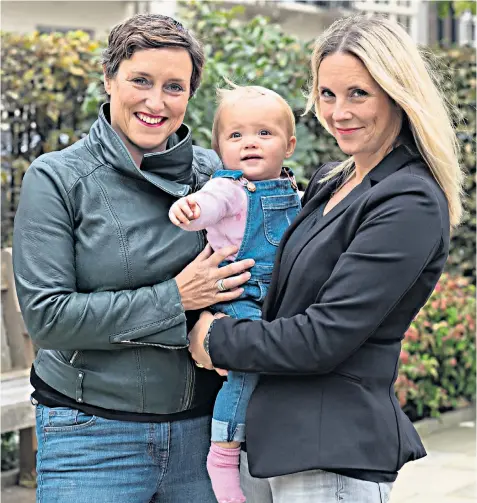  ??  ?? Fighting for the future: Sue Baker, left, director of mental health charity Time to Change, with wife Alex and baby Pip