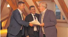  ?? FOTO: JENNIFER KUHLMANN ?? Christoph Ewen vom Forum Energiedia­log (rechts) überreicht den Abschlussb­ericht an die Bürgermeis­ter Stefan Bubeck (links) und Jochen Spieß.