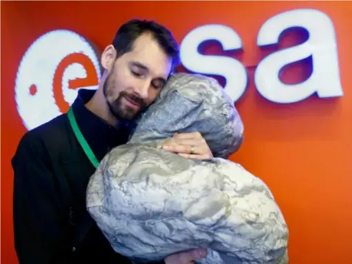  ?? (Reuters) ?? European Space Agency worker Mattial Malmer with a pillow in the shape of the 67P comet