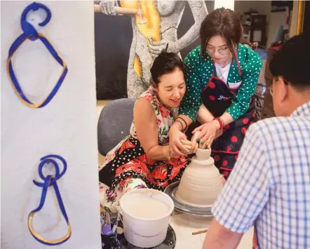  ?? PHOTOS BY OLIVIA HARLOW/THE NEW MEXICAN ?? Heidi Loewen, left, helps Rim Seon-mi — the team manager of exchange and cooperatio­n from Icheon, South Korea — make a piece (detail above) inside the Heidi Loewen Porcelain gallery Thursday.