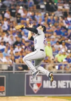  ?? Jamie Squire, Getty Images ?? Rockies third baseman Nolan Arenado leaps to barehand the ball on an infield hit by the Royals’ Eric Hosmer during the fourth inning Tuesday night at Kansas City.