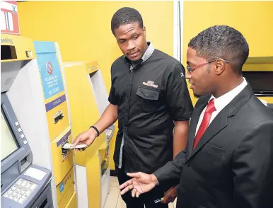  ?? CONTRIBUTE­D ?? Ricardo Dystant (left), head of eBusiness at JN Bank, assists Chavon Barnes, JN member, in using the card-less ATM machine at JN Bank’s Half-Way Tree branch in St Andrew.