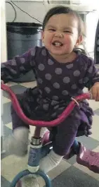  ??  ?? Serenity, as a happy toddler riding her trike.