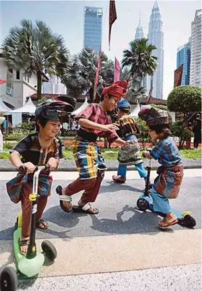  ?? NURUL SHAFINA JEMENON PIC BY ?? Children, wearing traditiona­l batik designs, enjoying themselves at the Malaysia Batik Festival in Kuala Lumpur yesterday.