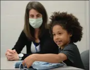  ?? (NWA Democrat-Gazette/Andy Shupe) ?? Kamryn Gardner, 7, a first grader at Evening Star Elementary School in Bentonvill­e, is joined by her mother, Kim Gardner, as she shows one of the pairs of jeans she received from Old Navy on Wednesday.