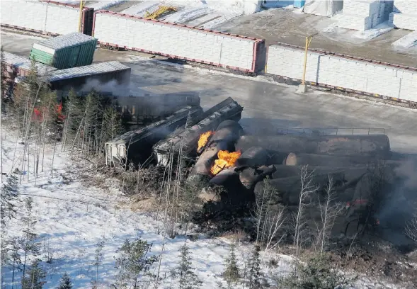  ?? Tom Bateman/The Canadian Press ?? A CN freight train carrying crude oil and propane derailed Tuesday night in northweste­rn New Brunswick. The cars continued to burn Wednesday.