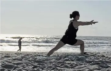  ?? THOMAS FROESE PHOTO ?? A Pilates instructor at Cocoa Beach, Fla., stretches during in this 2019 moment captured by contributo­r Thomas Froese. Writing about why New Year’s resolution­s rarely work, he notes, “If nothing else, be kind to yourself in 2021.”