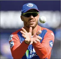  ?? — AFP ?? Delhi Capitals’ David Warner catches the ball during the IPL match against Mumbai Indians.