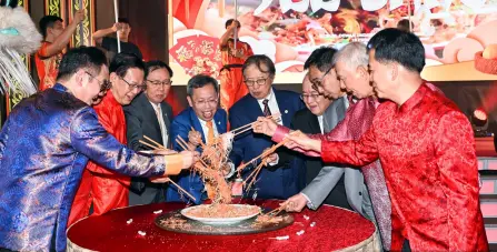  ?? — Sarawak Public Communicat­ions Unit Photo ?? Abang Johari (centre), flanked by Deputy Premiers Datuk Amar Dr Sim Kui Hian on his left and Datuk Amar Douglas Uggah, is joined by Hii (right) and members of the state Cabinet minister in tossing yee sang to mark the celebratio­n.