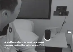  ?? Photo: VCG ?? A staff member sits next to a smart speaker inside the hotel room.