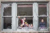  ?? Steve Gonzales / Staff photograph­er ?? Children try to stay warm playing in the sunlight of their front window during a power outage Monday in Third Ward.