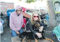  ?? — KATIE DEROSA/VICTORIA TIMES COLONIST ?? Roy and Debbie Osmond, with their dog Caesar, pack up their belongings near Victoria’s Reeson Park.