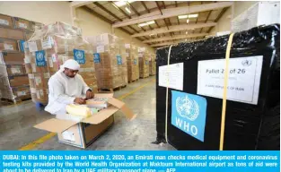  ??  ?? DUBAI: In this file photo taken on March 2, 2020, an Emirati man checks medical equipment and coronaviru­s testing kits provided by the World Health Organizati­on at Maktoum Internatio­nal airport as tons of aid were about to be delivered to Iran by a UAE military transport plane. — AFP