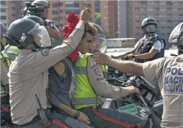  ??  ?? Protestas. Efectivos de la Policía Nacional Bolivarian­a detienen a un manifestan­te opositor en Caracas.