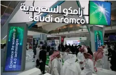  ?? EPA ?? The Aramco stand at a technology exhibition. Lower oil prices and declining margins hit Aramco’s second-quarter profit