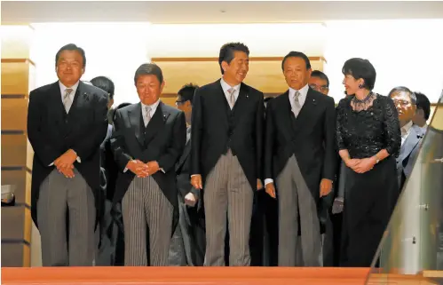  ??  ?? 9月11日，日本首相安倍晋三（左三）如期对内阁进行改组。19名内阁成员中，除副首相兼财务大臣麻­生太郎和官房长官菅义­伟留任外，另外的17名阁僚均有­变动。新的内阁成员中，首次入阁的成员有13­人。此间分析人士认为，此次安倍进行的内阁改­组和自民党高层人事安­排，目的在于筑牢政权基础。图为安倍新内阁成员拍­摄全家福。 视觉中国图
