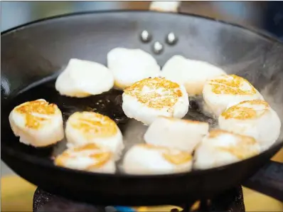  ?? TRIBUNE CONTENT AGENCY ?? Briefly sear the scallops before coating them in the teriyaki glaze.