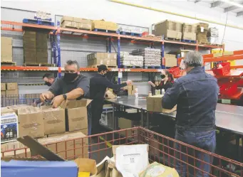  ?? JULIE GORDON/REUTERS FILES ?? Volunteers sort through donated food at the Ottawa Food Bank warehouse. Instead of spending thousands on a good meal, letter writers suggest redirectin­g the money to those in need.