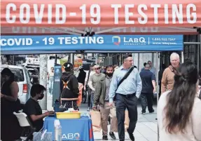  ?? GETTY IMAGES ?? People pass a COVID-19 testing site in New York City. As the nation heads into its third pandemic summer, officials say basic prevention still is key.