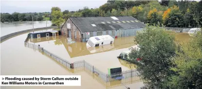  ??  ?? &gt; Flooding caused by Storm Callum outside Ken Williams Motors in Carmarthen