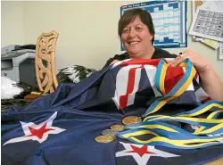  ??  ?? World Champion powerlifte­r Sonia Manaena sits in her office at work with her medals, flag, cloak and Maori Champions Award back in 2012. LOUISE BERWICK/STUFF