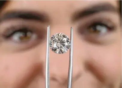  ?? Steve Gonzales photos / Houston Chronicle ?? Caroline Farr displays a laboratory-grown diamond at Wolf Diamonds, a local retailer that began selling the synthetic gems in 2014. Owner Bryan Vaughn says sales have taken off and show no signs of slowing.