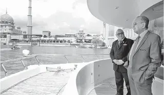  ?? — Gambar Bernama ?? Tun Dr Mahathir (kanan) melihat pemandanga­n Putrajaya dari atas kapal cruise Sebarau pada majlis makan tengah hari di atas cruise semalam.