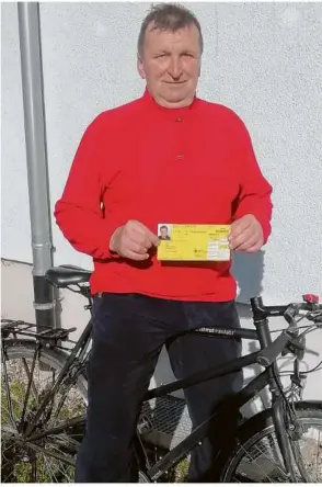  ?? Foto: Thomas Grüninger ?? Stefan Goniak mit zwei Utensilien, die er häufig gebraucht: sein Fahrrad und den Blutspende­r-ausweis.