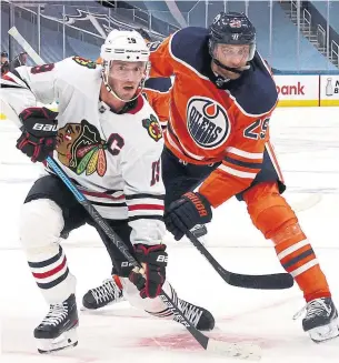  ?? DAVE SANDFORD GETTY IMAGES ?? Blackhawks forward Jonathan Toews and Oilers forward Leon Draisaitl face off on the ice in Edmonton on Saturday. Toews scored twice and Draisaitl had one goal.