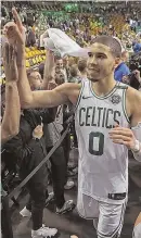  ?? STAFF PHOTO BY MATT STONE ?? CROWD PLEASER: Jayson Tatum celebrates as he walks off the Garden floor after the Game 5 victory against the 76ers.