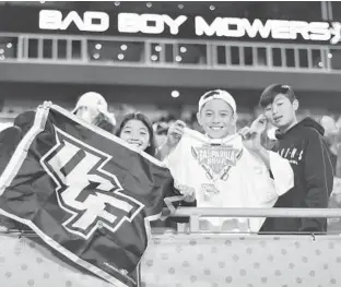  ?? LULIO AGUILAR/GETTY ?? Young UCF Knights fans pose for a photo during the fourth quarter against Marshall at the 2019 Gasparilla Bowl at Raymond James Stadium in Tampa.