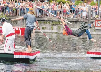  ??  ?? Im Halbfinale des 86. Langenarge­ner Fischerste­chens befördert der spätere Sieger, der „Rote Germane“, den Fischer in die erfrischen­den Fluten des Hafenbecke­ns.