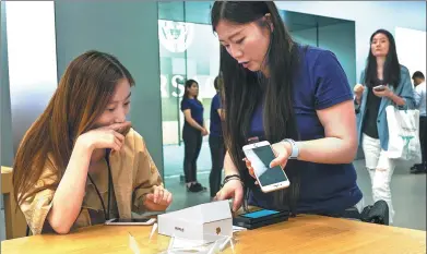  ??  ?? A woman buys an iPhone 8 Plus at an Apple showroom in Shanghai on Friday. The Apple iPhone 8 and 8 Plus have gone for sale in China starting Friday.