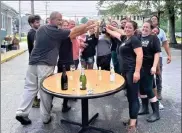  ?? ?? Luccas American Kitchen owners John and Jodi Davick toast their July 20 wedding anniversar­y last year with their staff and kids in the parking lot of their Leominster restaurant, which was destroyed by fire just three days earlier.