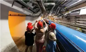  ??  ?? Bright minds: visitors take pictures at the Cern particle physics research facility. The Large Hadron Collider is 27km long. Photograph: Ronald Patrick/Getty Images