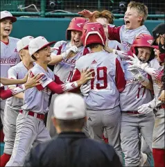  ?? GENE J. PUSKAR/ASSOCIATED PRESS ?? Sioux Falls, S.D.’S Gavin Weir (19) celebrates with teammates as he crosses home plate after hitting a three-run home run off Lake Oswego, Ore.’s Ben Robertson during the fifth inning of a Little League World Series game in South Williamspo­rt, Pa., on Monday.