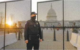  ?? Gabrielle Lurie / The Chronicle ?? A Capitol Police officer stands watch as National Guard troops make their way to the U.S. Capitol.