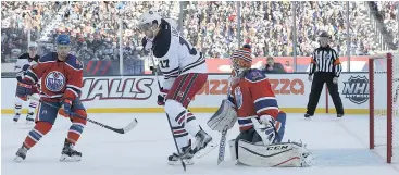  ?? — GETTY IMAGES ?? Adam Lowry of the Jets tries to deflect a shot past Oilers goalie Cam Talbot during the Heritage Classic game in Winnipeg. Talbot’s Oilers blanked the Jets 3-0.