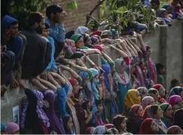  ?? — AP ?? Kashmiri villagers watch the funeral procession of top rebel commander Gulzar Ahmed Paddroo in Aridgeen, about 75 kilometers south of Srinagar, on Saturday.