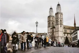  ?? Michael Buholzer / Associated Press ?? Swiss voters line up along the Muenster Bridge in Zurich to cast their ballots in a referendum on legislatio­n that authorized the use of virus passes. The measure passed by a wide margin.